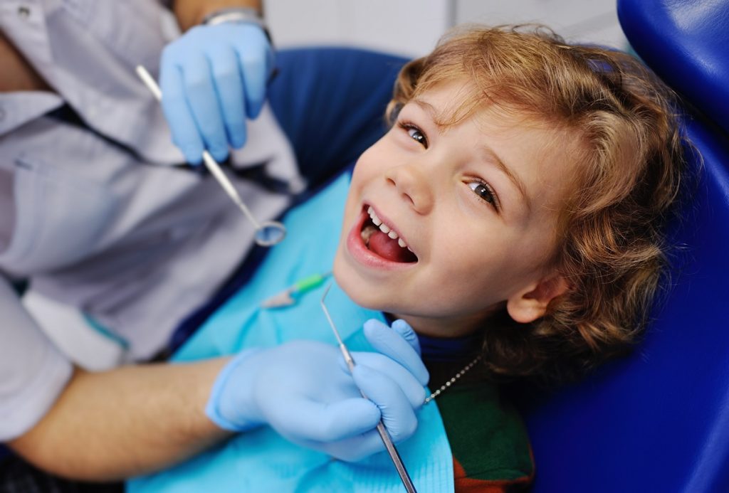 Kid smiling on dentist chair