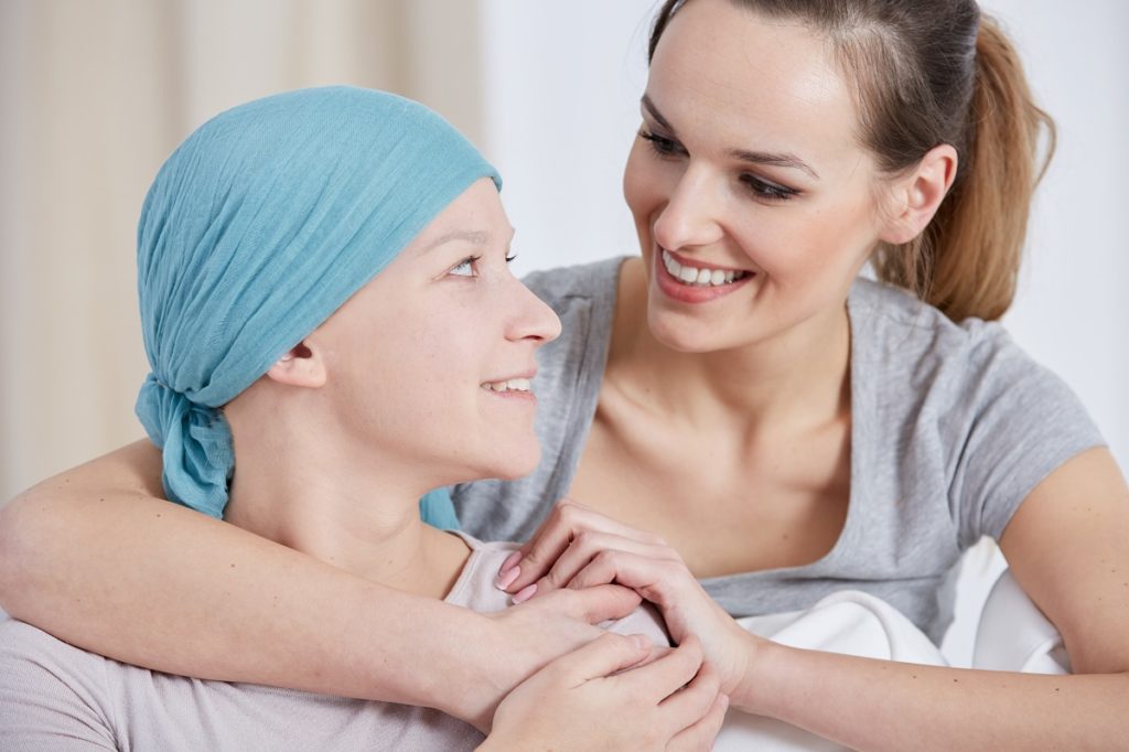 Woman with cancer being embraced