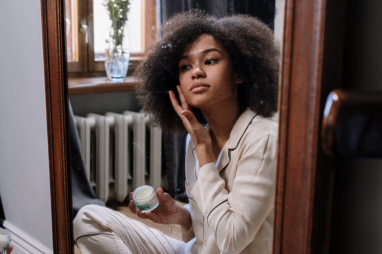 woman applying cream to her face