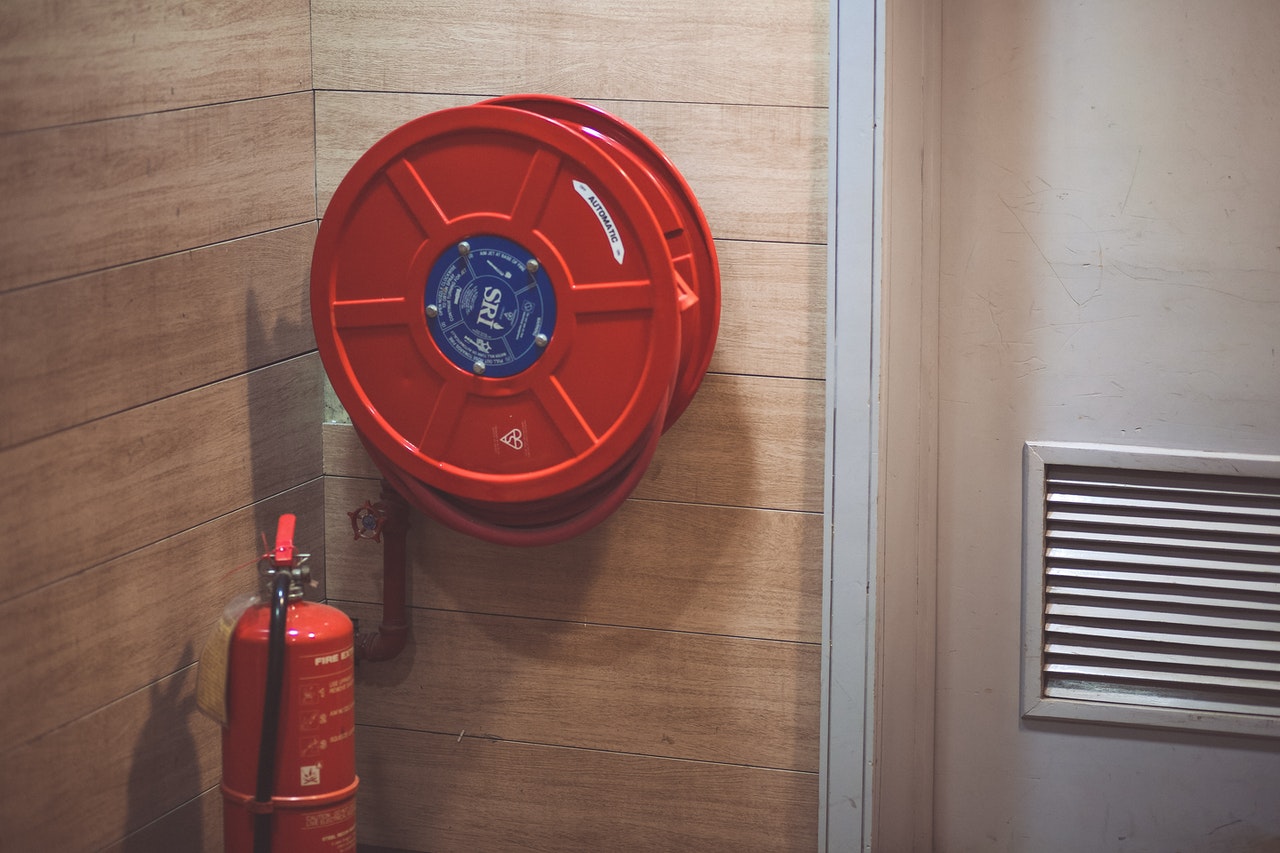 fire extinguisher next to a hose reel