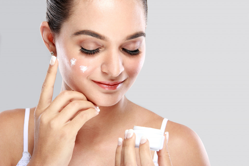 woman using sunscreen on her face