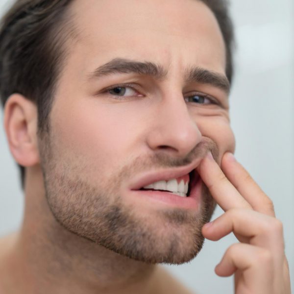 Man checking his teeth and looking disturbed