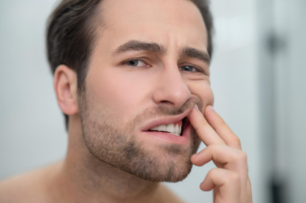 Man checking his teeth and looking disturbed